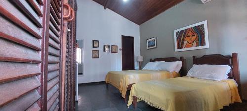 a room with two beds in a hotel room at Encantos do mar in Arraial do Cabo
