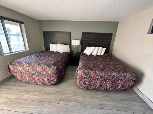 two beds sitting next to each other in a room at Palms Inn in Gila Bend