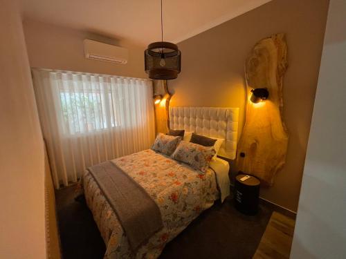 um pequeno quarto com uma cama e um candeeiro em Ambientes do Rio Home em Sacavém