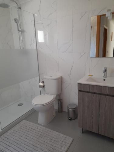 a bathroom with a toilet and a tub and a sink at Leiria Village casa zen in Leiria