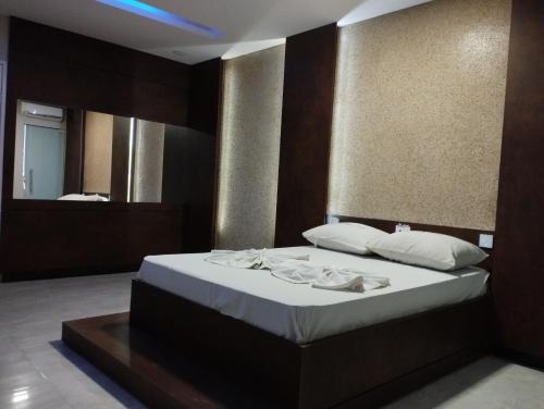 a bedroom with a bed with white sheets and a mirror at Motel FLEX LOVE LAMARAO in Aracaju