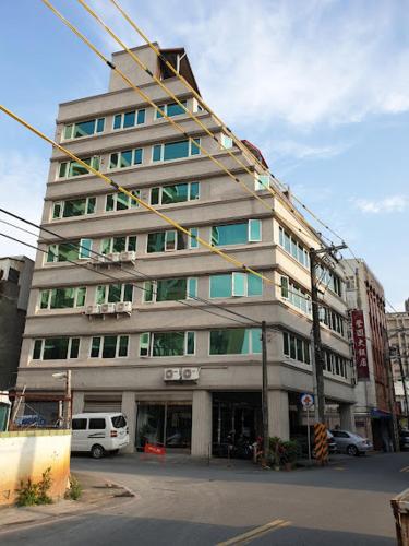 um edifício alto numa rua da cidade com uma rua em 登園大飯店 em Wei-ch'ien