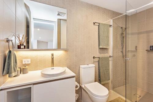 a bathroom with a toilet and a sink and a shower at Coastal Souls North Kirra Beach in Gold Coast