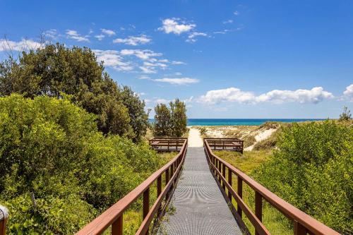 a wooden boardwalk leading to a beach with the ocean at Coastal Souls North Kirra Beach in Gold Coast