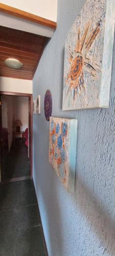 a hallway with two paintings on a wall at Encantos do mar in Arraial do Cabo
