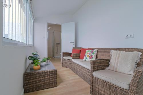 a living room with two wicker chairs and a table at Casa do Arco in Ponta Delgada