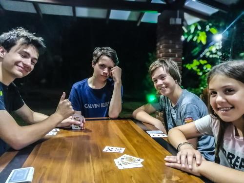 a group of young people sitting around a table playing cards at Green Cottage in Anuradhapura