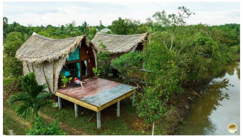 an aerial view of a house with a table next to the water at Villa Baan Pak Pra in Ban Pak Pra (1)
