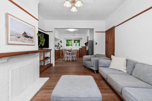 uma sala de estar com um sofá e uma lareira em Charming Cottage Escape - Pet friendly! em Geelong West