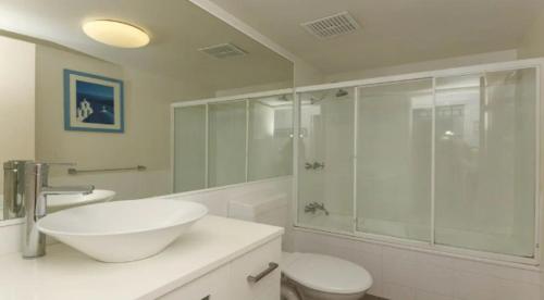 a bathroom with a sink and a glass shower at Grande Florida - Hosted by Burleigh Letting in Gold Coast