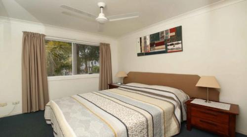 a bedroom with a bed and a window at Grande Florida - Hosted by Burleigh Letting in Gold Coast