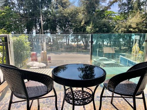 a patio with a table and chairs and a tennis court at Emma in Ban Pak Khlong Phe