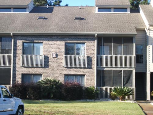a brick house with windows and a car parked in front at Unique 2 Bedroom / 2 Bath Condo in Myrtle Beach in Myrtle Beach