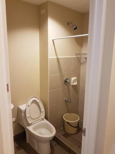 a small bathroom with a toilet and a shower at Keys N Places @ Avida Aspira in Cagayan de Oro