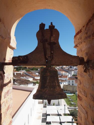 a large bell hanging from a wall in a building at Hotel Convento Aracena & SPA in Aracena