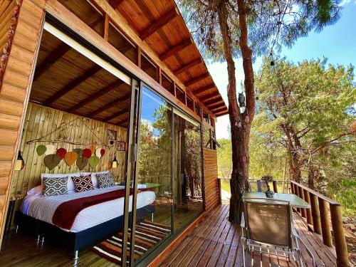 a bedroom on the deck of a tree house at Alma de Campo Glamping - Laguna de Suesca in Suesca