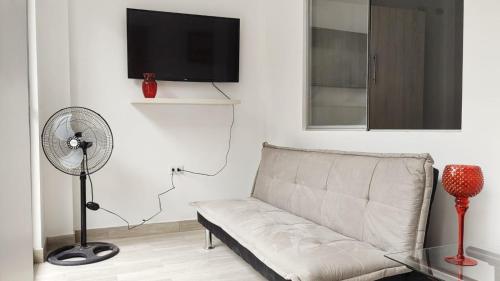 a living room with a couch and a fan at Edificio Sánchez Cerro in Piura