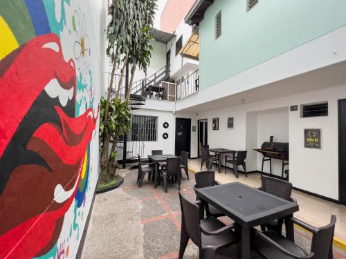 a patio with tables and chairs and a colorful wall at Rock Hostel Medellin in Medellín