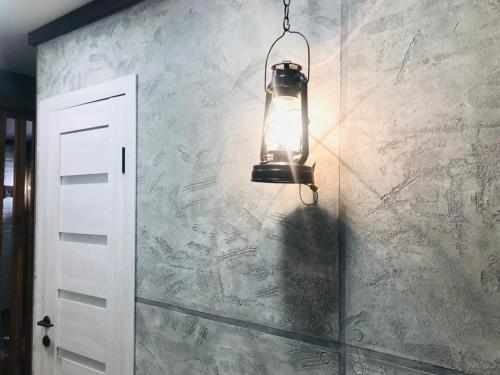 una luz colgando de una pared junto a una puerta en Квартира в стиле лофт для гостей Караганды en Karagandá