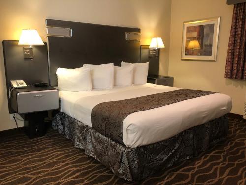 a hotel room with a large bed and a phone at Casa Royal Inn in San Jose