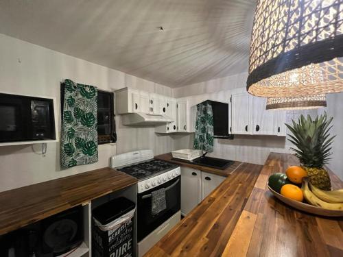 a kitchen with a bowl of fruit on a wooden table at Over The Hill Residence in Saint Martin