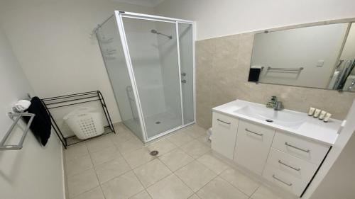 a white bathroom with a shower and a sink at Unit 48 Seafront Estate in Jurien Bay