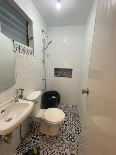 a bathroom with a toilet and a sink and a shower at Atria's Bed & Breakfast at Laiya in Laiya