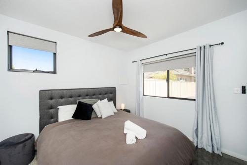 a bedroom with a large bed with a ceiling fan at Bayside Luxury Escape Busselton with WiFi in Busselton