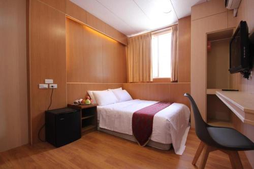 a hotel room with a bed and a desk and a television at 日月潭 -日月住館 in Yuchi