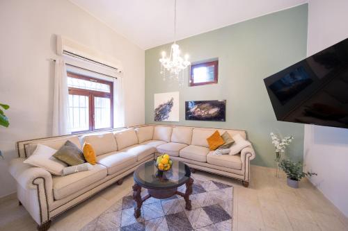 a living room with a couch and a table at Art Apartment In Mamila - Villa Rehavia in Jerusalem