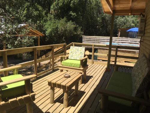eine Terrasse mit einer Bank, einem Tisch und einem Sonnenschirm in der Unterkunft Cabañas Lihuén SPA in Parral