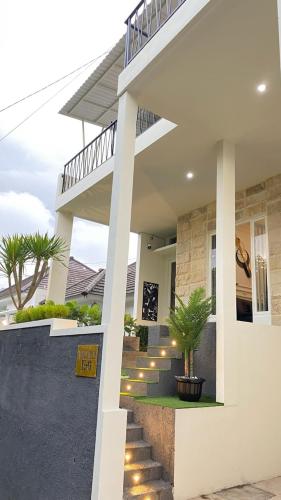 a house with a staircase leading to the front entrance at The Glory Villas in Batu