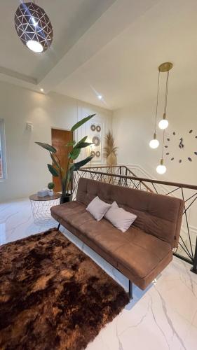a living room with a brown couch in a room at The Glory Villas in Batu