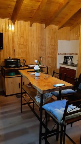 a room with a wooden table and a kitchen at Cabañas Lihuén SPA in Parral