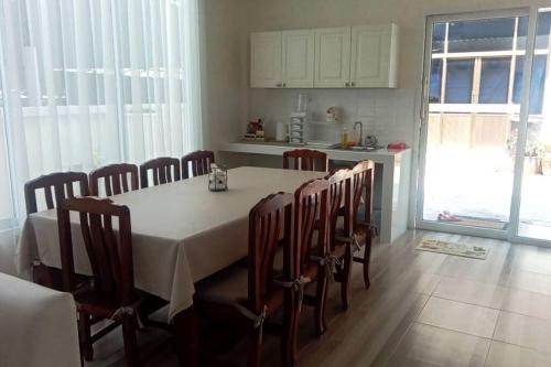 a dining room with a table and chairs in a kitchen at Na - cha - lae (3) in Chanthaburi