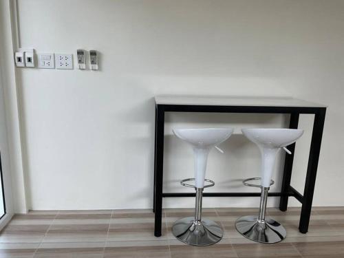 a black table with two wine glasses on a floor at Na - cha - lae (3) in Chanthaburi