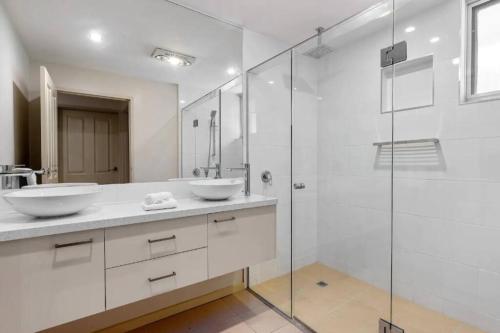 a bathroom with two sinks and a glass shower at Yera Lodge Coastal Homestead in Rye Spa/Tennis Crt in Rye