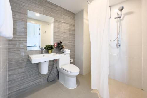a bathroom with a toilet and a sink and a mirror at Wellness Stay & Hotel Sukhumvit 107 in Bangna