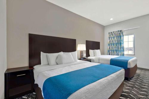 a hotel room with two beds and a window at Studio 6-Pleasanton, TX in Pleasanton