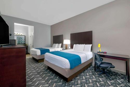 a hotel room with two beds and a television at Studio 6-Pleasanton, TX in Pleasanton