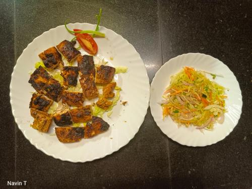 two white paper plates with food on a table at Tathagata Farm in Darjeeling