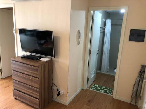 a bathroom with a television on a dresser with a mirror at Madison Park Apartment 2 Bedroom near Central Park Mall in Jakarta