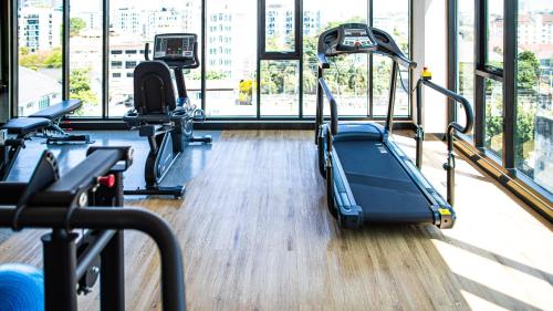 a gym with several treadmills in a building at Wellness Stay & Hotel Sukhumvit 107 in Bangna