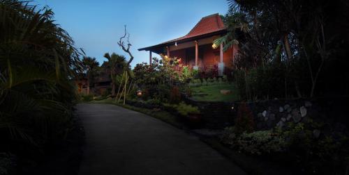 a house with a pathway leading to a house at The Sanyas Retreat in Tabanan