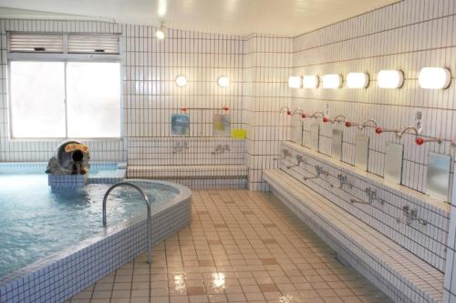 a large bathroom with a tub with a dog in it at 川内ホテル in Satsumasendai