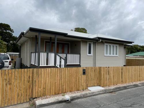 a house with a wooden fence in front of it at 13 Cypress Lane in Woorim