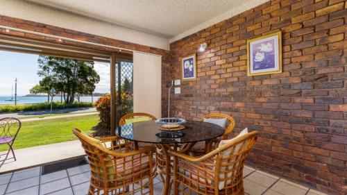邦加里Ground Floor with water views and pool!的一间设有桌椅和砖墙的用餐室
