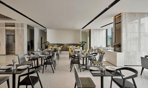 a restaurant with tables and chairs in a room at December Hotel in Nha Trang