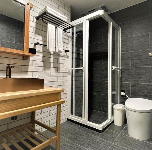 ein Bad mit einer Glasdusche und einem WC in der Unterkunft 95 Pavilion in Jiufen