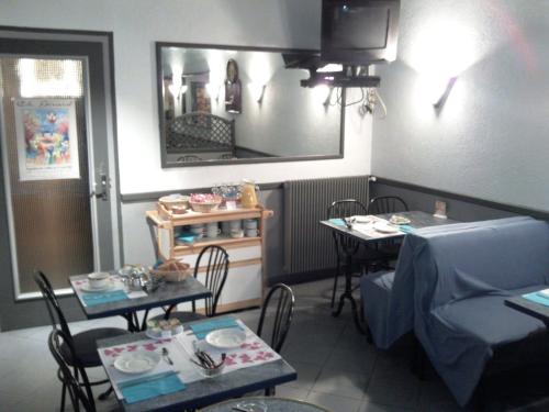 a dining room with a table and two tables with chairs at Hotel Le Chapitre in Aubusson